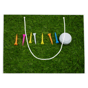 Golfball mit T-Shirts auf grünem Rasen Große Geschenktüte