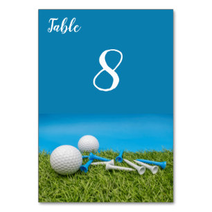 Golfball mit T-Shirts ist auf Gras und blau Tischnummer