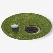 Golfball neben Loch auf grünem Gras Golfplatz  Pappteller (Schrägansicht)