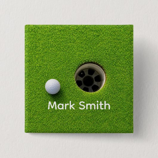 Golfball neben Loch auf grünem Rasen Golfplatz  Button (Vorderseite)