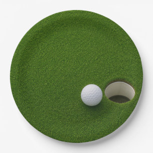 Golfball neben Loch auf grünem Rasen Golfplatz  Pappteller