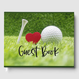 Golfball und Abschlag auf grünem Gras mit Liebe Gästebuch