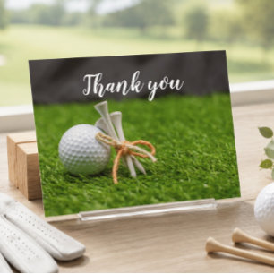 Golfball und Tee sind auf grünem Gras Vielen Dank Postkarte