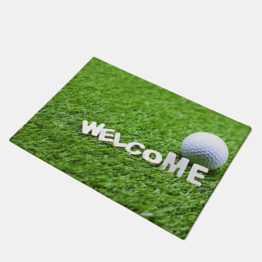 Golfball und Willkommenswod auf Gras Fußmatte (Schrägansicht)