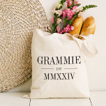Grammie römisches Jahr Tragetasche<br><div class="desc">Diese minimalistische Totentasche,  die eine schicke Oma feiert,  zeichnet sich durch eine minimalistische Tasche aus,  die "Grammie" oder Ihre Wahl von Oma-Spitznamen in schwarzen Serifenschrift auszeichnet. Mit dem Jahr,  in dem sie zu einer Großmutter wurde,  in eleganten römischen Ziffern für eine schicke Touch.</div>