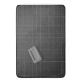 Graue Bar-Seife auf einem schwarzen Fliesenboden Badematte (Vorderseite Vertikal)