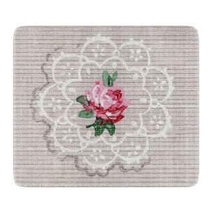 Graue Spitzendecke mit rosa Rosenmuster auf antike Schneidebrett