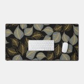 Graue und goldfarbene Blätter auf schwarz Schreibtischunterlage (Tastatur & Maus)