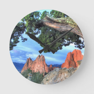 Grauer Felsen gerahmt durch Baum Runde Wanduhr