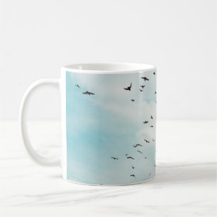 Grautaubenfliege am Vintagen blauen Himmel. Oben Kaffeetasse