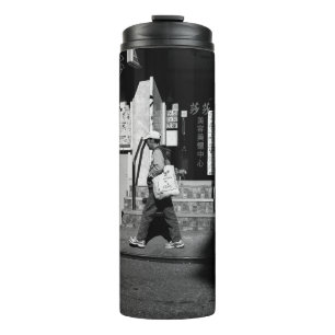GRAYSCALE FOTOGRAFIE VON PERSON, DIE NEBEN BUI ZU  THERMOSBECHER