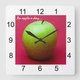 Green apple on red background quadratische wanduhr