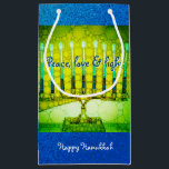 Green Blue Peace Liebe Light Hanukkah Menorah Bold Kleine Geschenktüte<br><div class="desc">"Frieden, Liebe und Licht." Eine nah-up Foto-Abbildung einer hellen, farbenfrohen, grünen und gelben künstlerischen Menorah vor dem Hintergrund eines blauen Imitats Glitzer hilft Ihnen, den Urlaub von Hanukkah im Stil. Genießen Sie die Wärme und Freude der Urlaubssaison, wenn Sie diese niedliche und lustige kleine Geschenktasche verwenden. Passende Karten, Porto, Aufkleber,...</div>