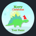 Green Christmas Dinosaurier Name Stickers<br><div class="desc">Grün Weihnachten Dinosaurier Name Stickers. Ein niedlicher kleiner grüner Cartoon Dinosaurier Stegosaurus mit einer roten Weihnachtsmannmütze in einer sonnigen Schneelandschaft mit Schneeflocken, die vom Himmelsrundaufkleber mit Ihrem Namen und Text "Frohe Weihnachten" fallen. Füllen Sie Ihren Namen aus, um Ihre Weihnachtsdinosaurier Aufkleber persönlich zu machen! Dieser Dinosaurier-Aufkleber ist vollständig anpassbar, fügen...</div>