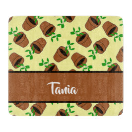 Green plant in terracotta pot on yellow schneidebrett