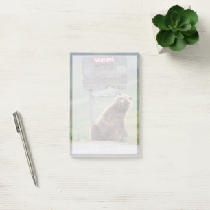 Grizzlybär spielt mit Schild Post-it Klebezettel