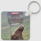 Grizzlybär spielt mit Schild Schlüsselanhänger (Rückseite)