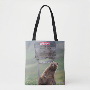 Grizzlybär spielt mit Schild Tasche