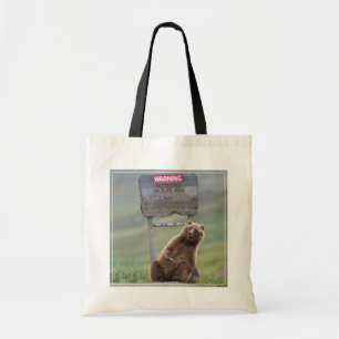 Grizzlybär spielt mit Schild Tragetasche
