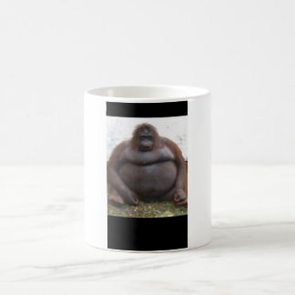 Großer Affe, der sich hinsitzt Kaffeetasse
