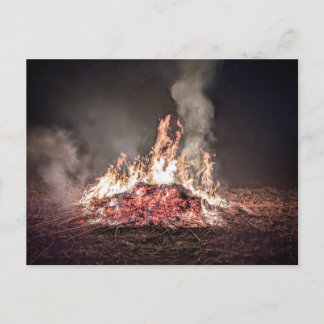 Großes Lagerfeuer, das nachts mit hohen Flammen br Postkarte
