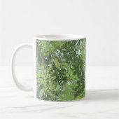 Grüne Blätterbäume mit blauem Himmel, die durch Ku Kaffeetasse (Links)