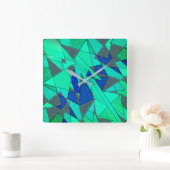 Grüne dreieckige Ausschnitte auf blauem Hintergrun Quadratische Wanduhr (Zuhause)