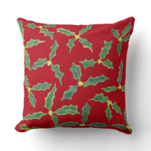 Grüne Holly-Blätter, gelbe Blumen auf roten Kissen