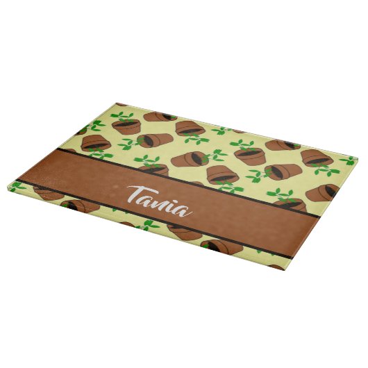 Grüne Pflanze aus Terrakotta auf gelb Schneidebrett (Ecke)