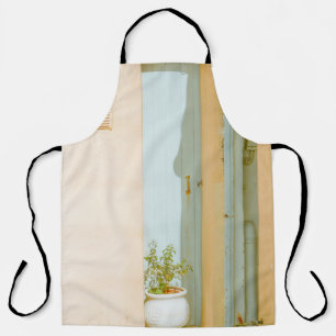 GRÜNE PFLANZE MIT KERAMIK VASE NEBEN WEISSEM HOLZ  SCHÜRZE