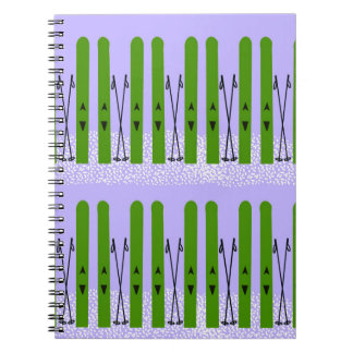 Grüne Skier auf lila Notebook Notizblock