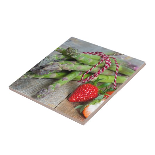 Grüner Spargel mit Erdbeeren auf Holz Fliese (Seite)