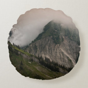 GRÜNER UND GRAUER BERG UNTER WEISSEN WOLKEN RUNDES KISSEN