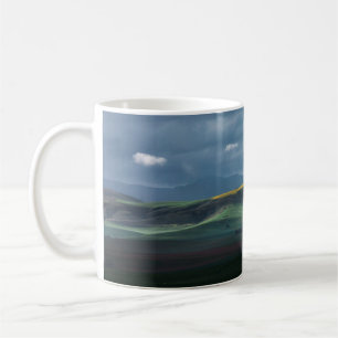 GRÜNES GRASFELD UNTER BEWÖLKTEM HIMMEL WÄHREND DES KAFFEETASSE