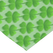 Grünes vierblättriges Kleeblatt auf Limettengrün Tischdecke (Schrägansicht)