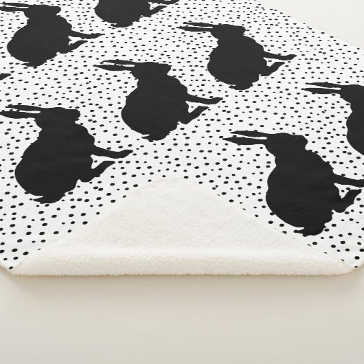 Gruppe sitzender Hasen mit schwarzer Silhouette Sherpadecke (3/4)