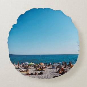 GRUPPE VON PERSONEN, DIE DEN GARANTIERTEN STRAND B RUNDES KISSEN
