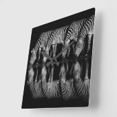 Gruppe von Steppenzebras trinkt nachts zusammen Quadratische Wanduhr (Winkel)