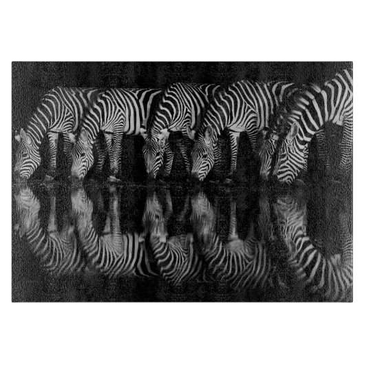 Gruppe von Steppenzebras trinkt nachts zusammen Schneidebrett (Vorderseite)