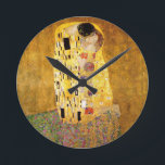 Gustav Klimt Das klassische Kiss-Gemälde Runde Wanduhr<br><div class="desc">Gustav Klimt Der Kuss Gustav Klimt verwendete in seinem wunderschönen Werk Jugendstil-Frauen und Dekorationskunst echtes Gold. Dieses Klimt-Gemälde hieß "Der Kuss" und ist das bekannteste Jugendstil-Werk, das er je gemalt hat. Das Gemälde Gustav Klimt ist eine Jugendstil-Frau und Mann in einer Umarmung. Die Farben sind überwiegend gold - mit echtem...</div>