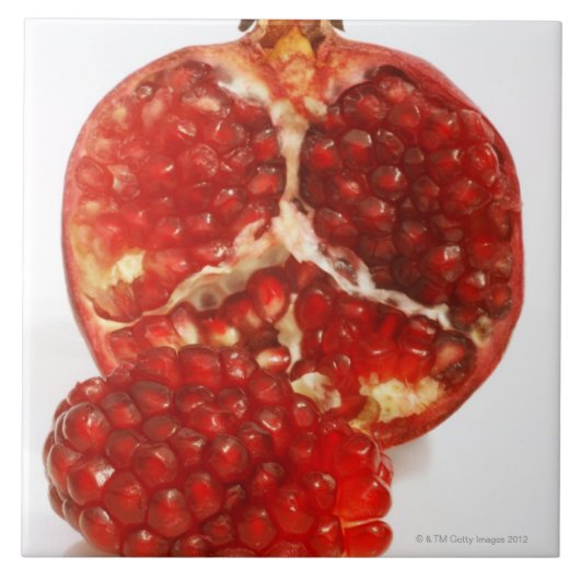 Hälfte ein reifer Granatapfelschnitt, zum das Fliese (Vorderseite)