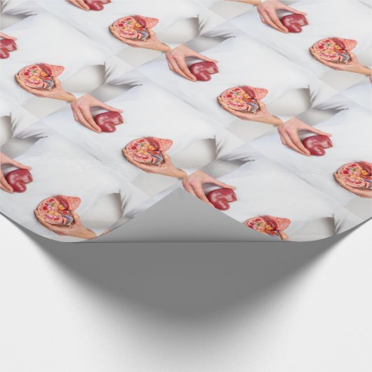 Hände, die Modell des menschlichen Nierenorgans am Geschenkpapier (Ecke)