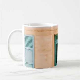 HAUS MIT GEÖFFNETEM FENSTER UND GESCHLOSSENER TÜR KAFFEETASSE