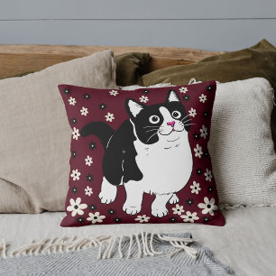 Hauskatze auf Niedlichem weißem schwarzen Burgund Kissen