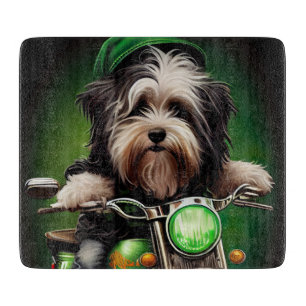 Havanese Hund fährt Fahrrad am St. Patrick's Day Schneidebrett