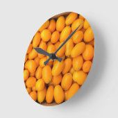 Heap of orange kumquats in cardboard box runde wanduhr (Winkel)