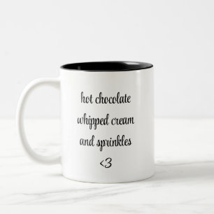 heißes schokoladengepeitschtes Sahne und Sprinklen Zweifarbige Tasse