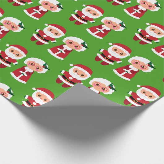 Herr und Frau Santa Clause über einen grünen Hinte Geschenkpapier (Ecke)