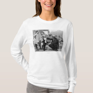 Herr und Kinder, die mit Bärenjunges auf Leas T-Shirt