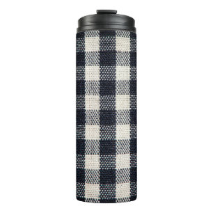 Hintergrund aus kariertem Baumwollstoff. Thermosbecher